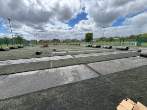 In progress image of the artificial surface being stripped off of the football field.